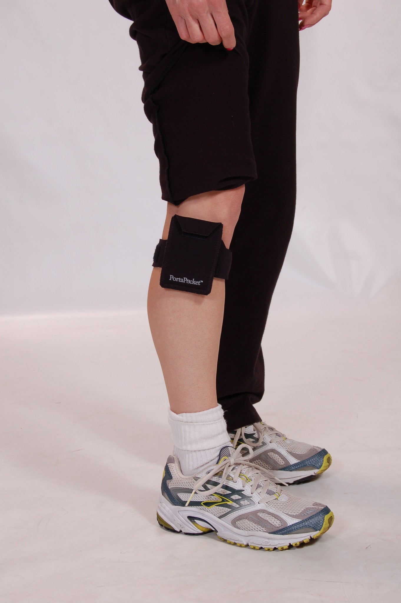 Workout pants lifted to show where PortaPocket pocket is hiding on leg
